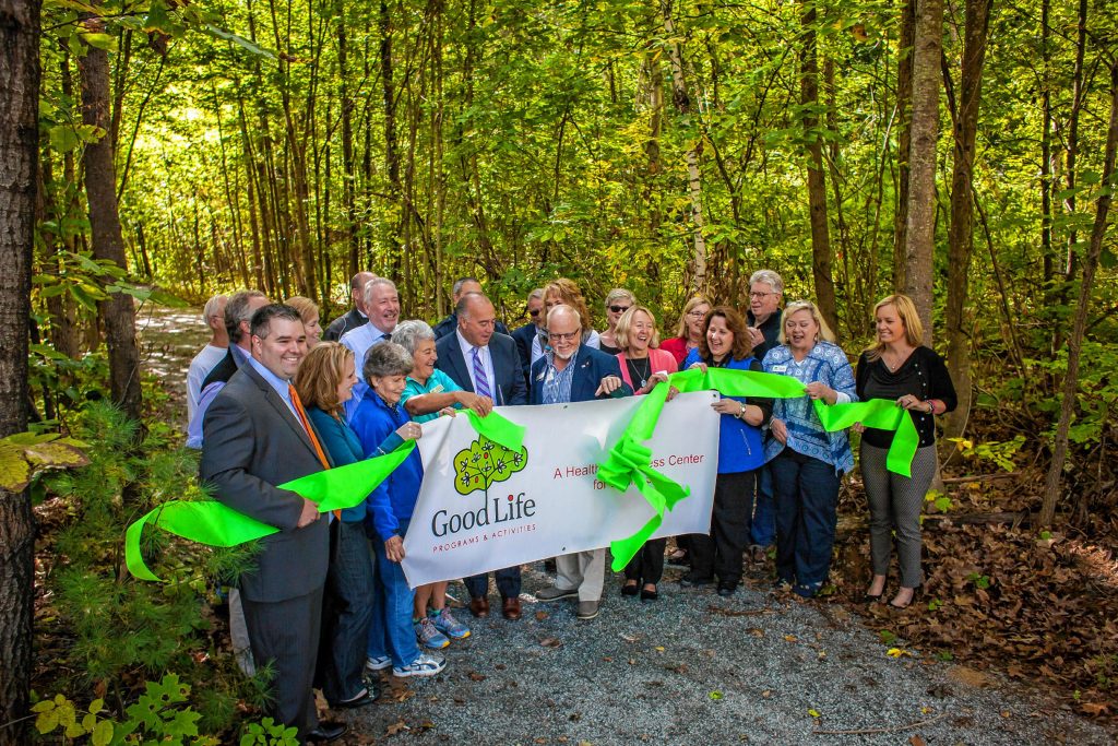 Mayor Jim Bouley makes the cut during the ribbon cutting ceremony at Smokestack Center in Concord on Oct. 6, 2016. Owners of Smokestack and their tenants, such as GoodLife Programs & Activities, hope the short trail is only the start of a larger vision for the wooded area off the centerâs parking lot. (ELIZABETH FRANTZ / Monitor staff) ELIZABETH FRANTZ