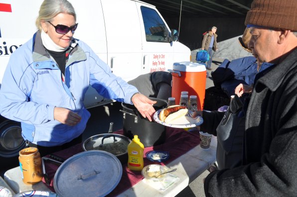 Mary Corliss of Larck Family MIssions serves a sausage sandwich with all the fixins’ to Wendell Ford. The group has been in Concord for a little more than six months and has served as many as 50 lunches on several Saturdays.