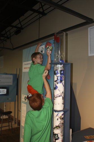 Camper Cole Forkey, 6, stretches to put another piece of memory in the tube as he climbs the “Memory Wall,” part of the Center’s current “Beyond Images” exhibit.