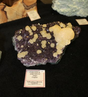 I’m no mineral expert, but that looks like an amethyst loaded with calcite crystals to me.