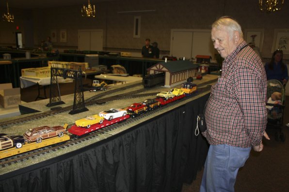 Train enthusiast Bill Hodges watches a small diesel automobile freight cruise by.