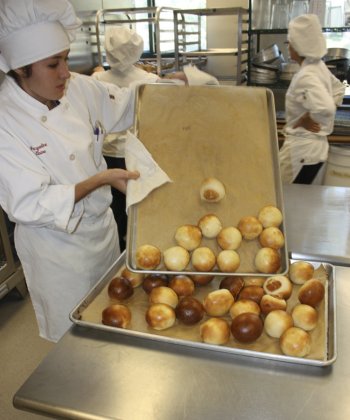 Jackie Williams handles a panful of rolls, fresh from the oven.