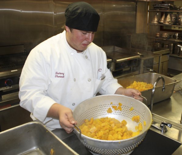 Zachary Theriault with a steaming colander full of pumpkin, perfect for a tasty pumpkin bisque.