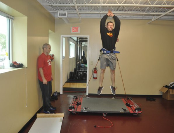 What the heck is that contraption? John Lahey demonstrates the use of a machine designed to increase an athlete’s vertical leap.