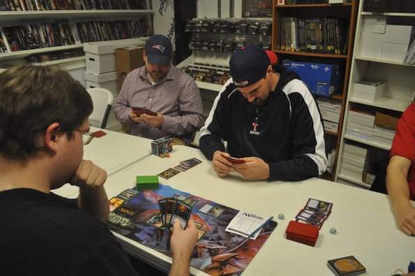 Matthew Knapp, Jay Carlage and Francis O’Rourke entrenched in a Magic: The Gathering duel.