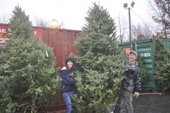 Kaitlyn Witts and Tom Arnold hoist one of the larger trees remaining at Arnie’s Place on Loudon Road.