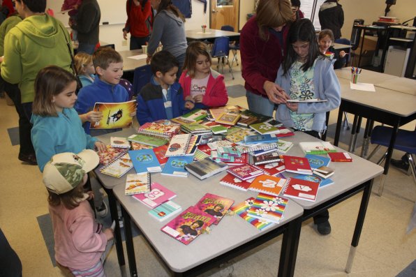 Children gather around to select their journals at the fourth annual New Hampshire Family Literacy Day, held at Merrimack Valley High School. Over 1,700 children participated in the event and over 11,000 books were given away, thanks to donations from local businesses.