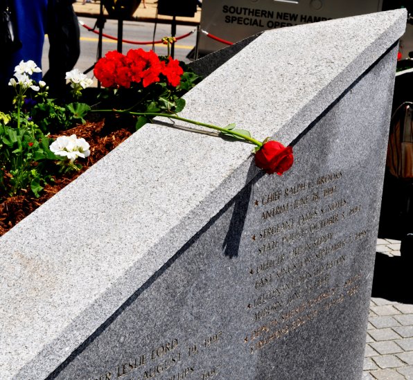 A single rose is left beside the names of fallen officers.