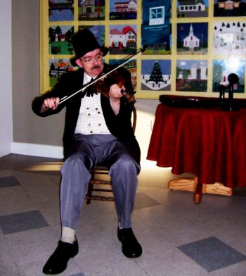 Adam Boyce fiddling in character as Charles Ross Taggart.