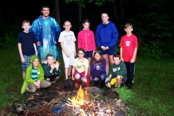 The Explorers stand around a fire, which they somehow built out of wet wood!