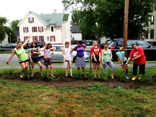 The ladies of Girls Inc. take a break to strike a pose as they work on a garden at the West Street Ward House.