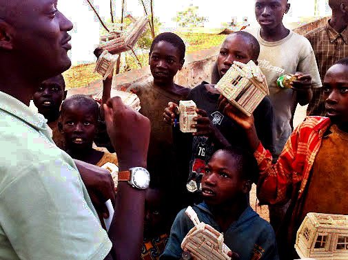 The Rev. Ndgijimana Fulgence talks to some Burundian children selling handmade toys.