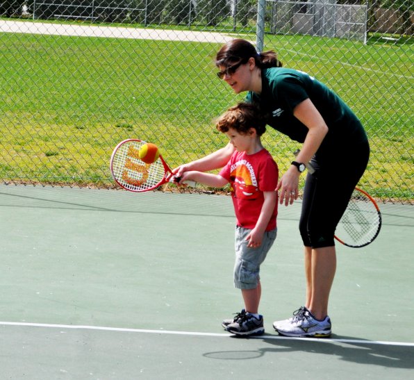 Laura Bryant of the Recreation Department helps Max Buckland get his tennis swag on.