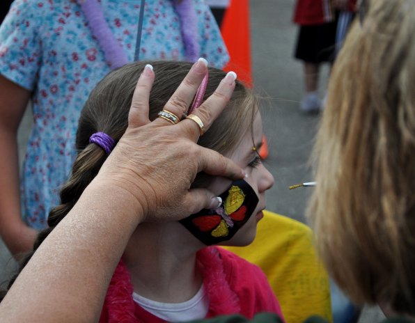 Elliana Hackett has her face painted by Anne Omundson.