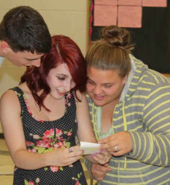 Timmy Shea, Chelsea Newell and Angelique Dukette, now high school seniors, marvel at photos from the time capsule.