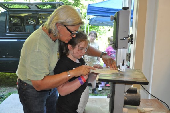 Elaine Hamel of Girls At Work teaches Arianna Laliberte how to use a table saw.