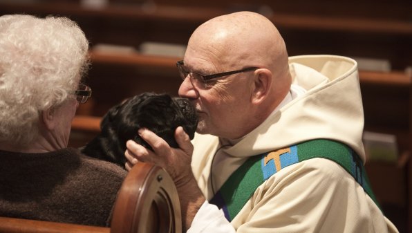 Rev. Charles Edward LeClerc is thanked by one of the many dogs at St. Paul’s Blessing of the Animals.