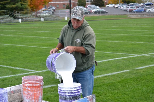 It wouldn’t be much of a game without a field to play it on. Tom “Kite” Wright takes care of that, lining the grass a few days ahead of time. Here, he mixes some of the roughly 40 gallons required to paint the field each week.