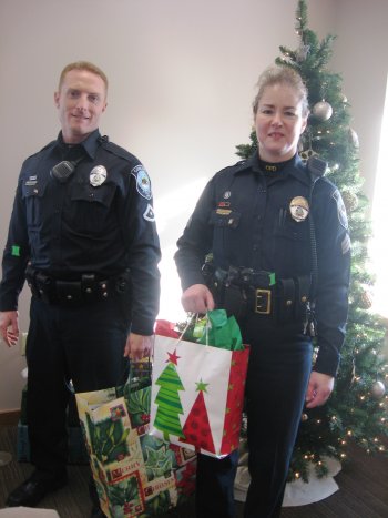 Concord Police Department officer Ryan D. Howe, left, and Sgt. Ranee L. Boyd deliver presents.