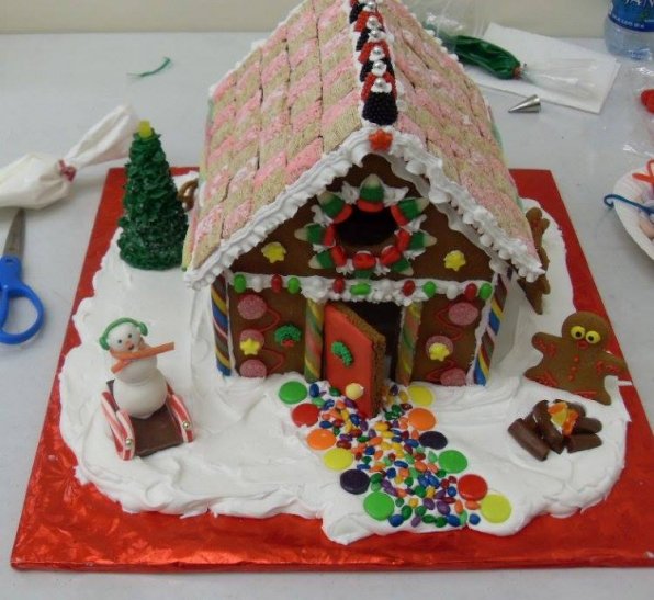 A Mini-Wheat roof, a wide-eyed gingerbread man in front of a roaring fire and a snowman with a wind-swept scarf and sleigh with candy cane walls (adult workshop.)