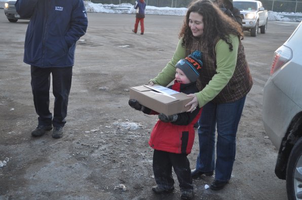 Jacob Littlefield and his mom, Sarah Littlefield, hand out some of the food Jacob collected at his birthday party.