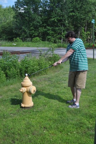 Tim got turned around trying to find one hole and his ball somehow landed on this hydrant in the Monitor parking lot, where he found it a few days later. Here he is trying to knock it back toward the hole (he finished that hole with a gazillion-bogey.)