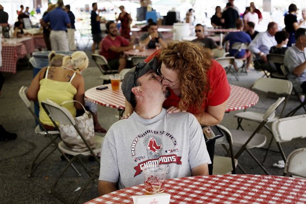 Rob Little of Pittsfield cranes his neck to give his wife, Meredith, a kiss at Market Days in July 2012.