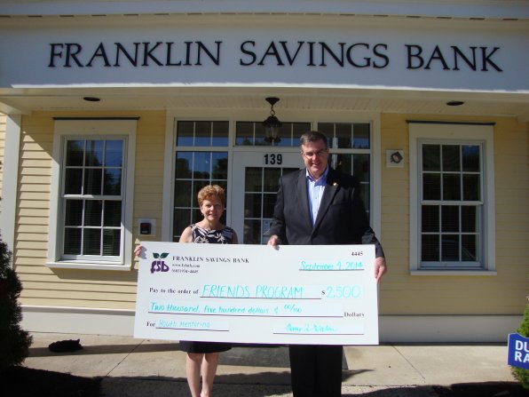 Nancy Watson of Boscawen, branch  supervisor of Franklin Savings Bank, presents Friends Program Executive Director Jerry Madden with the check.