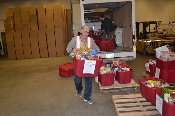 Steve Painchaud, sporting a nifty orange vest, grabs some bins from the annual lawyer food drive.