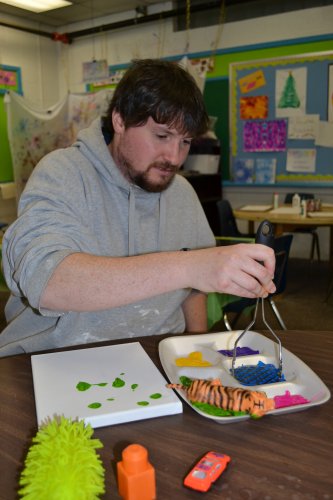 Tim begins working on his canvas masterpiece with help from a potato masher.