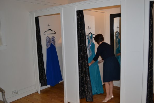 Bravo owner Tina Smith puts a couple of fancy-looking prom gowns in the comfy dressing rooms in her store.
