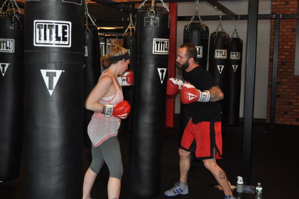 Heidi Gaffney and trainer Paul Gaffney work the same heavy bag during a class.