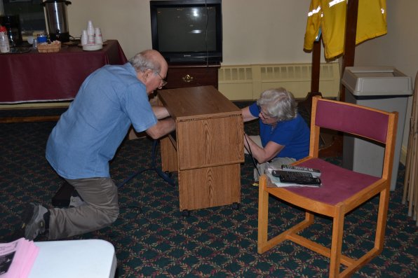 While it may seem like Merwyn and Carol Bagan are holding hands under the TV stand, they were actually just straightening out the wires.