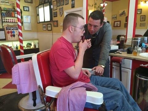 Nicholas Seybold gets a lesson in shaving from James Carroll at Lucky’s.