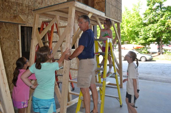 Construction technology teacher John Hubbard discusses the best place to put an opening in the floor  with a group of students.