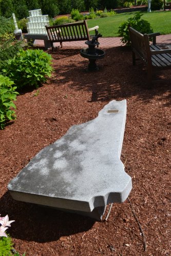 A granite bench in the shape of the Granite State.