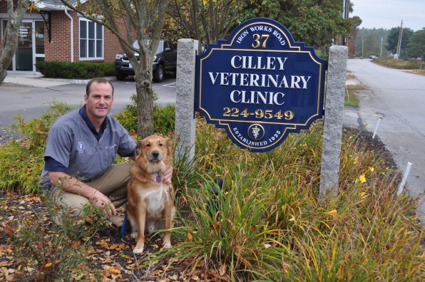 Dr. Tom Heck just bought this lovely sign – and the veterinary practice that comes with it. He has taken over the Cilley Veterinary Clinic on Iron Works Road, and his buddy, Casey, can’t wait to put on the lab coat and get to work. Do they make those with four arm holes?