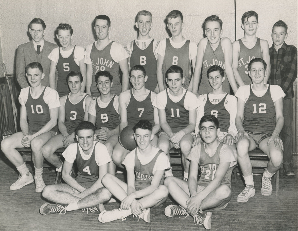 Here’s a photo of the 1951 St. John’s High School JV basketball team sent to us by reader Jack Fraser, from an era when haircut diversity was apparently not really a thing. Other stuff we dig in this photo: No. 5’s sort of shmedium jersey and the sweet striped shirt No. 8 is rocking under his uniform. The photo may be old, but the means to idenfity everyone were decidedly modern – Fraser, who was the coach of the team, thanked those who are on the “I’m from Concord” Facebook page for helping to identify everybody. Speaking of everybody, here they are: <strong>Back row, left to right:</strong> Coach John Fraser, John Muldowney, Jackie Clinton, Bob Boucher, John McCann, Bill Woods, Don Burke, Leo Smith. <strong>Middle Row:</strong> Bob Walsh, Bob Morse, Bob Neveux, David Walsh, Art Nolin, Don Addario, Don Soderstrom. <strong>Front Row (sitting):</strong> Joe Jenovese, Al DiCicco, Pat Alosa, Jr.
