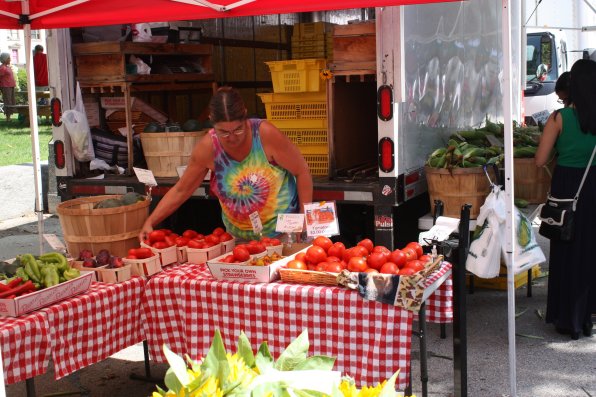 Diane Souther, owner of Apple Hill Farm in Concord, arranges some succulent tomatoes for farmers market patrons to peruse. Her produce was nearly as bright and colorful as her tie-dye shirt.