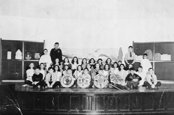 Check out this class photo of the 1941 Walker School sixth grade students, on the stage in the auditorium during a pageant about the Roman Empire. <strong>Front row, left to right:</strong> Albert Hood, Robert Brusia, Billy Erickson, Richard Morgan, Peter Fanny, Conky O’Connell, Doug Miniutti, Arthur Piroso. <strong>Second row:</strong> Phyllis MacKown, Ann Roberts, Yolanda Palisi, Jean Gaige, Marjorie Perry, Shirley Blodgett, Cynthia Cass, Christiana Stavros, UNKNOWN No. 1, Anna Karopilian, UNKNOWN No. 2, Hurley Lord. <strong>Third row:</strong> Wilma Crane, Beverly Datson, UNKNOWN No. 3, Alice Marston, Nancy Warren, Joan Bryant, UNKNOWN No. 4, Leo Taylor. <strong>Fourth row, standing:</strong> Richard Gourly, Robert Randlett, UNKNOWN No. 5, John Dahood.