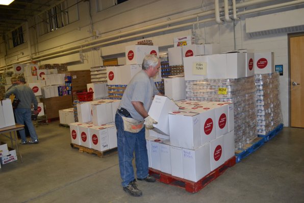 Lee Lajoie adds another box to the tomato products pallet during day one of the holiday basket operation last week. Lajoie has been doing it “fairly regularly” for the last 15 years and one reason is he doesn’t want to disappoint program chair woman Maria Manus Painchaud.