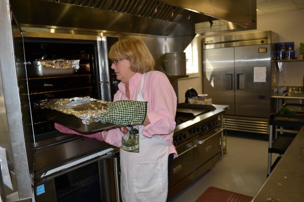 Carol Webster carefully removes a pan of American chop suey from the oven.