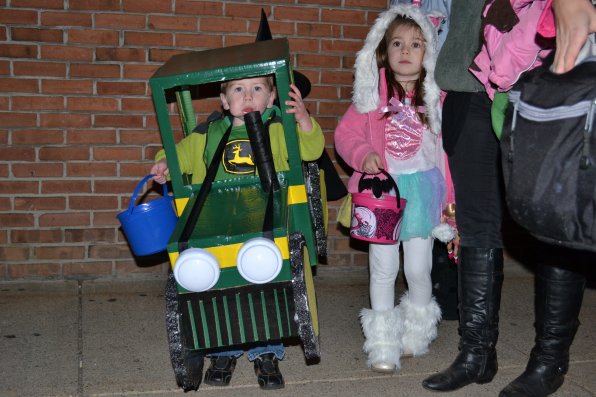 Colton Robichaud, 2, parks his John Deere costume and enjoys a lollipop while waiting to add more candy to his bucket.