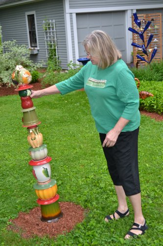 Liz Hebbel with the leaning tower of recycled garden art stuff.