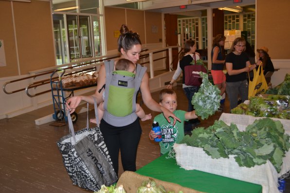 Lexxton helps his mom Justine Kelley pick out some kale, while Liviana enjoys the ride