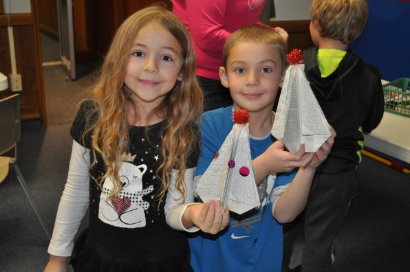 Brooklynn Reno, 6, and Jadin Sargent, 7, show off their Christmas tree craft at the library last week.