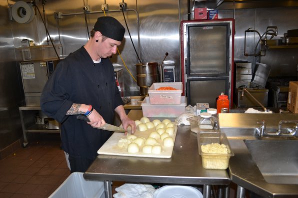 Ryan Blazon of the Concord Co-op chops what feels like a million onions for a batch of chicken noodle soup, the best seller at the Co-op’s soup station.