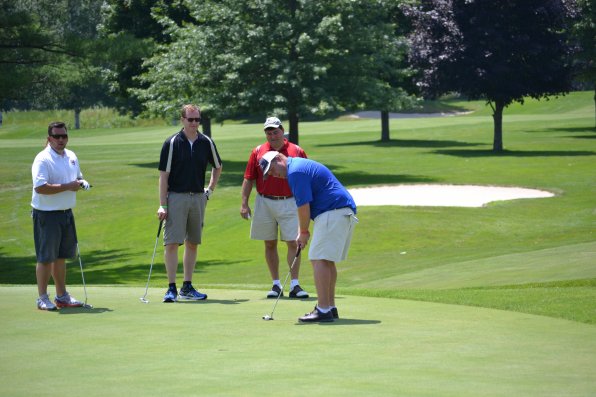 Ryan Towle lines up a putt under the watchful eyes of teammates, from left, Andy Davis (who is watching us), Erik Newman and Ari Pollack.
