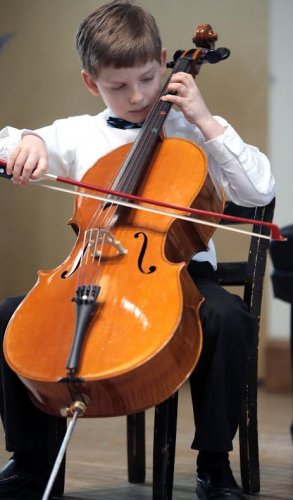 A dapper and bow-tied Neil Valle plays the cello at Performathon.