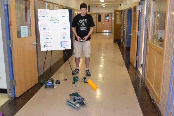 Kevin Kezar, a sophomore at NHTI, demonstrates just what Claw Bot is capable of during the Grand Opening of NHTI’s Robotics and Automation Lab on Wednesday. Unfortunately, the only thing Claw Bot did was pick up and drop an orange cylinder, but it was more than enough excitement for the small crowd.